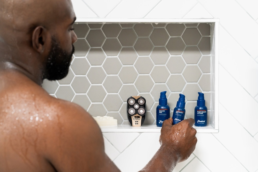 bald man applying pre shave oil